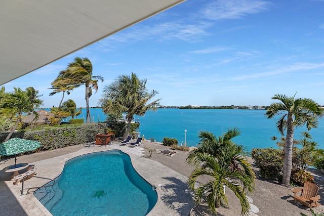 view of pool with a water view, a patio area, and a fenced in pool