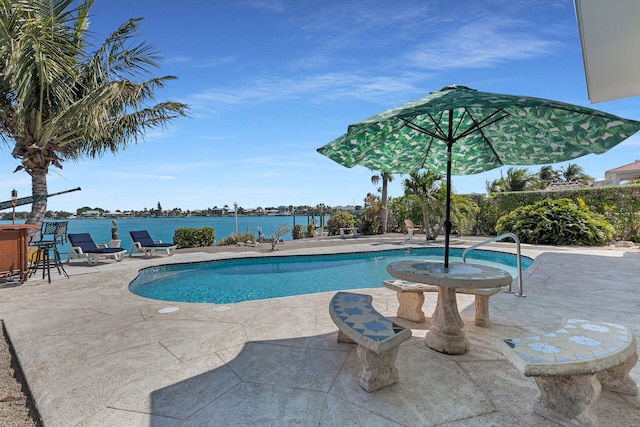 view of pool with a fenced in pool, a patio area, and a water view