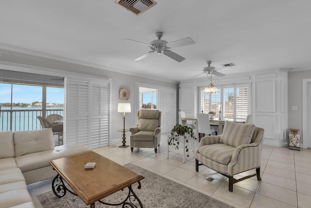 living room featuring a water view, light tile patterned floors, visible vents, and ornamental molding