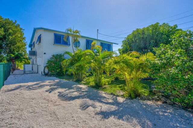 421 Ixora Dr, Big Pine, FL 33043 - view of front facade featuring fence, driveway, and stucco siding
