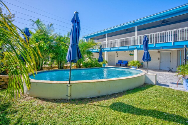 421 Ixora Dr, Big Pine, FL 33043 - outdoor pool featuring a lawn, ceiling fan, and a patio area