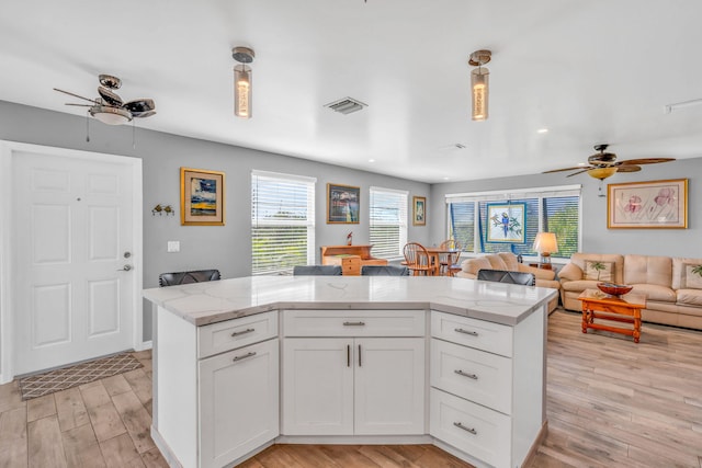 421 Ixora Dr, Big Pine, FL 33043 - kitchen with ceiling fan, light wood-style flooring, open floor plan, and white cabinets