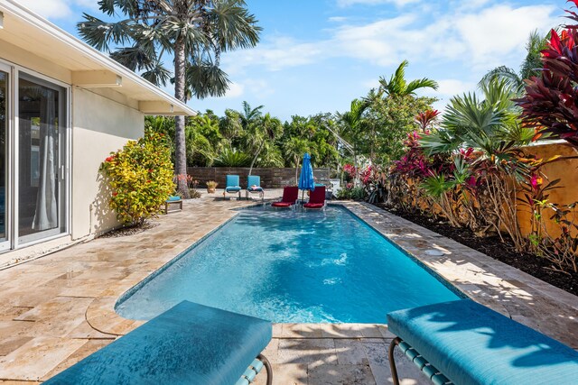 view of swimming pool featuring a fenced backyard and a patio