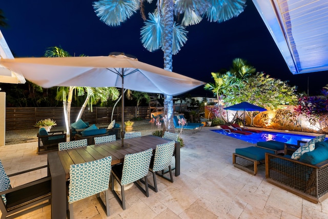 280 100th St, Ocean, Marathon, FL 33050 - patio at night with outdoor dining area, a fenced backyard, an outdoor hangout area, and a fenced in pool