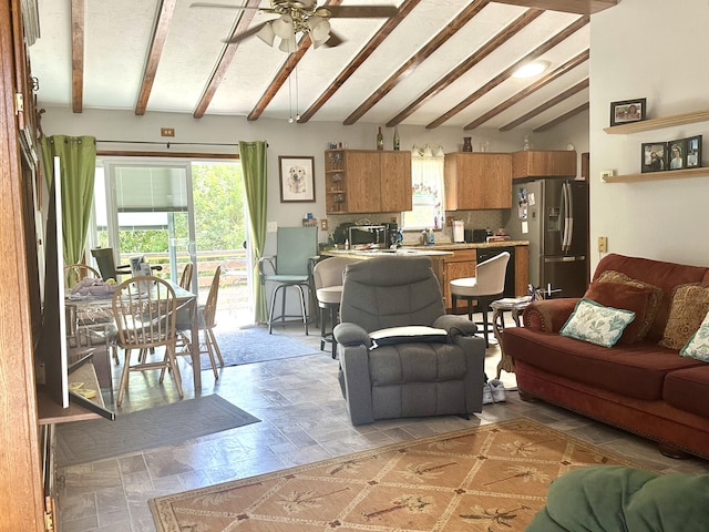 living area with a toaster, ceiling fan, and lofted ceiling with beams