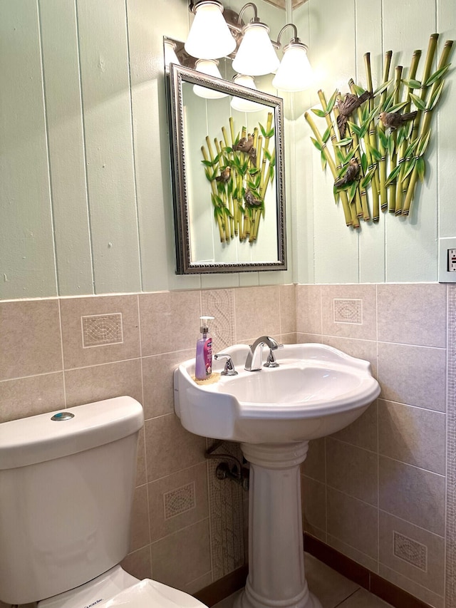 bathroom with tile walls and toilet