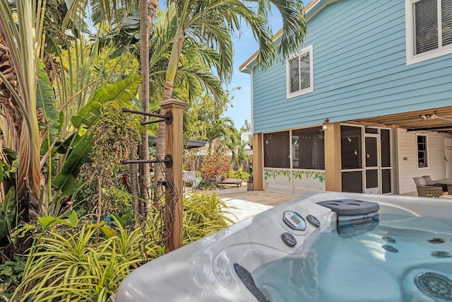 view of swimming pool featuring a patio area, a hot tub, and a sunroom