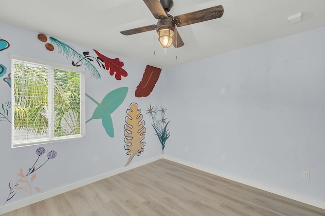 spare room featuring wood finished floors, baseboards, and ceiling fan