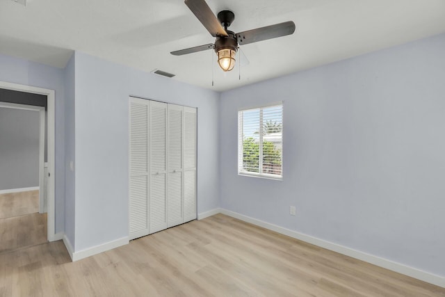 unfurnished bedroom with a closet, visible vents, light wood-style flooring, and baseboards