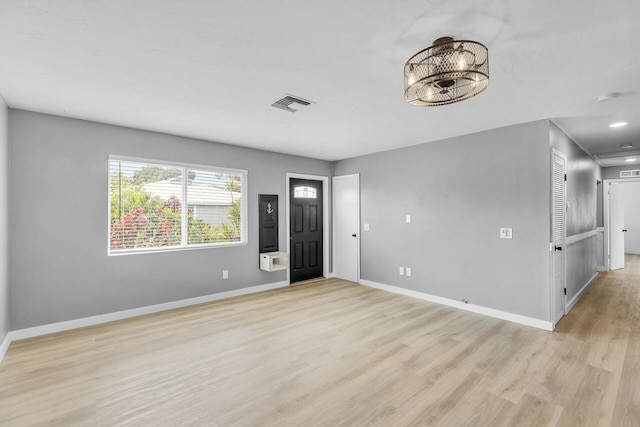 unfurnished room with wood finished floors, visible vents, and baseboards