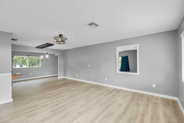 spare room with visible vents, light wood-type flooring, and baseboards