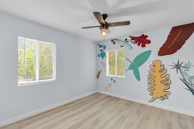 empty room featuring ceiling fan, baseboards, and wood finished floors