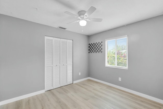 unfurnished bedroom with visible vents, ceiling fan, baseboards, wood finished floors, and a closet