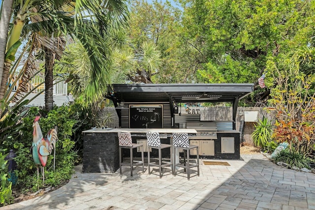 view of patio / terrace with area for grilling, outdoor dry bar, and fence