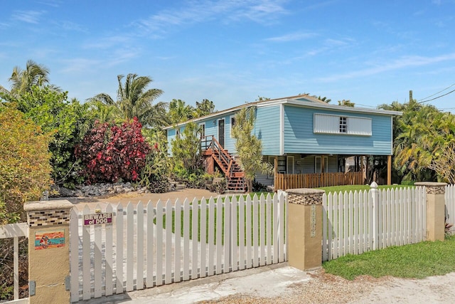 view of front of home featuring a fenced front yard and stairway