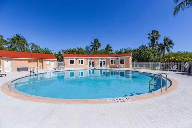 community pool featuring fence and a patio