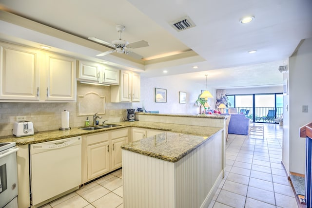 kitchen featuring white appliances, visible vents, open floor plan, hanging light fixtures, and a sink