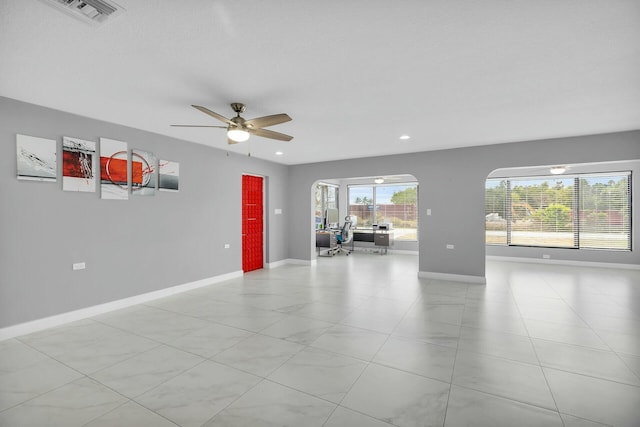 unfurnished living room with visible vents, baseboards, ceiling fan, and light tile patterned floors