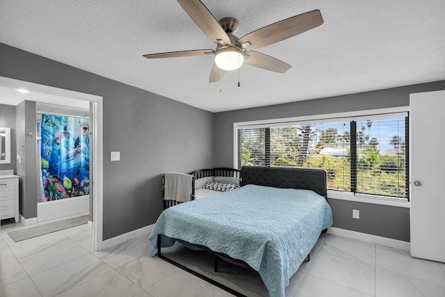 bedroom with a textured ceiling, marble finish floor, baseboards, and a ceiling fan
