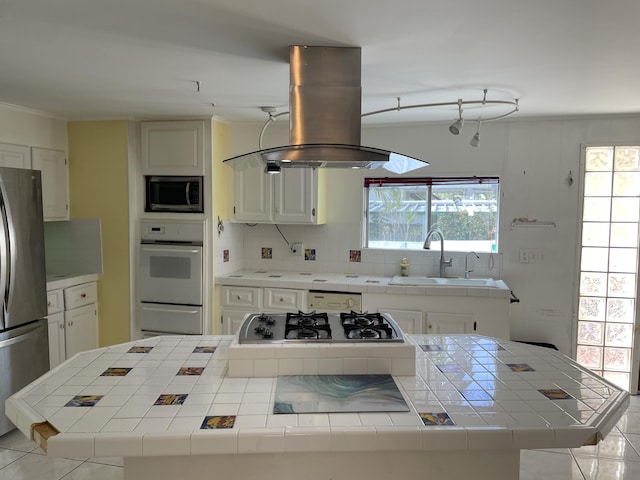 27858 Lobster Tail Trl, Little Torch, FL 33042 - kitchen featuring appliances with stainless steel finishes, tile countertops, island range hood, a sink, and a kitchen island