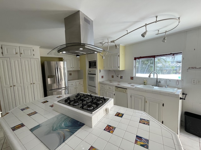 27858 Lobster Tail Trl, Little Torch, FL 33042 - kitchen featuring appliances with stainless steel finishes, island exhaust hood, tile counters, a sink, and backsplash