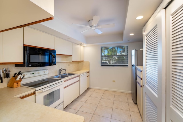 kitchen with white cabinets, white appliances, light countertops, and a sink