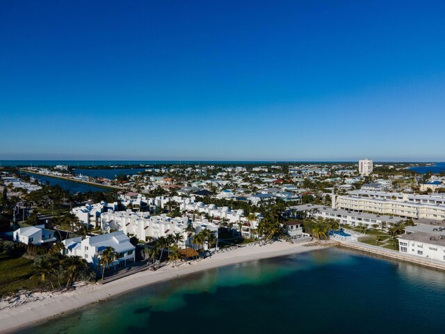 birds eye view of property featuring a water view, a beach view, and a city view