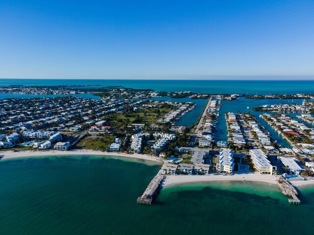 birds eye view of property with a water view and a beach view