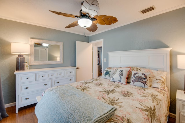 bedroom featuring baseboards, visible vents, a ceiling fan, ornamental molding, and wood finished floors