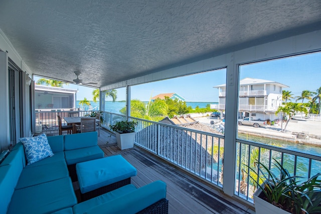 deck with ceiling fan, an outdoor hangout area, and a water view