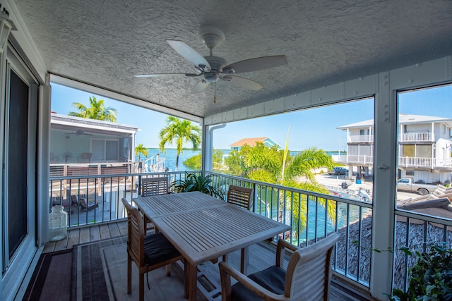 balcony with a water view and ceiling fan