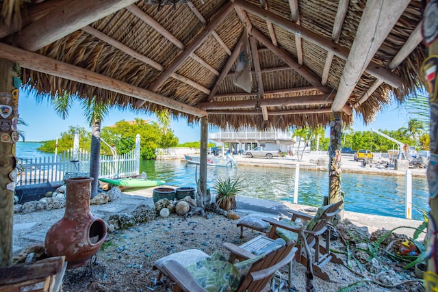 view of patio / terrace featuring a water view and fence