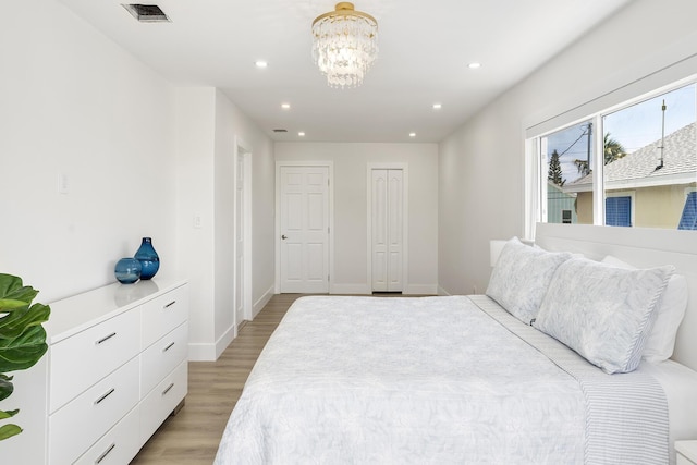 bedroom with visible vents, baseboards, light wood-style floors, a chandelier, and recessed lighting