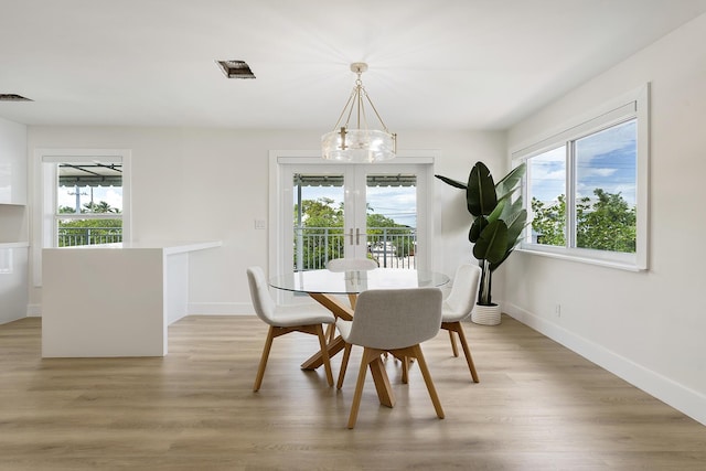 dining space with light wood-type flooring, french doors, a healthy amount of sunlight, and baseboards