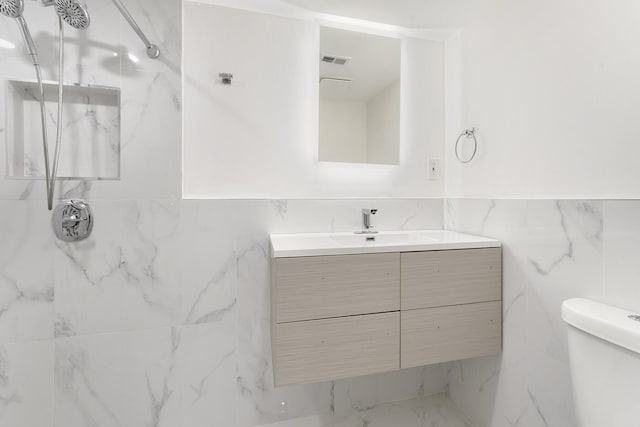 bathroom with visible vents, toilet, marble finish floor, walk in shower, and vanity