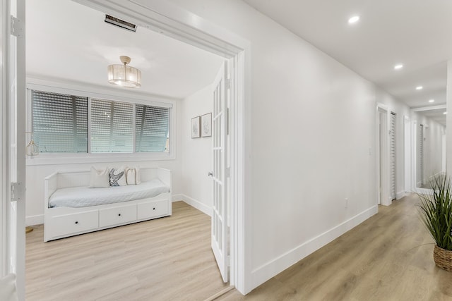 corridor with light wood-type flooring, baseboards, and recessed lighting