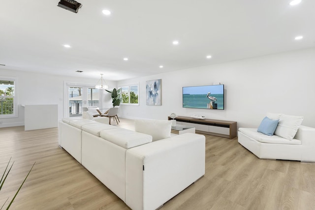 living area featuring light wood finished floors, an inviting chandelier, and recessed lighting