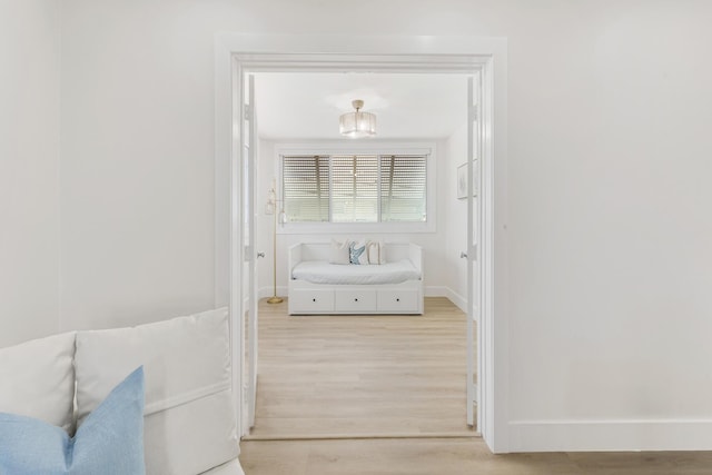 hall with light wood-style flooring and baseboards