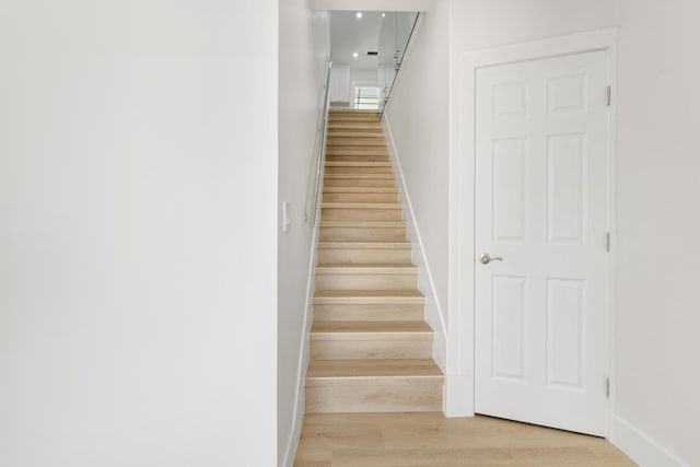 staircase with baseboards and wood finished floors