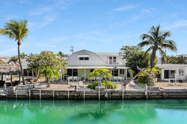 rear view of property with a water view, a patio area, and a balcony