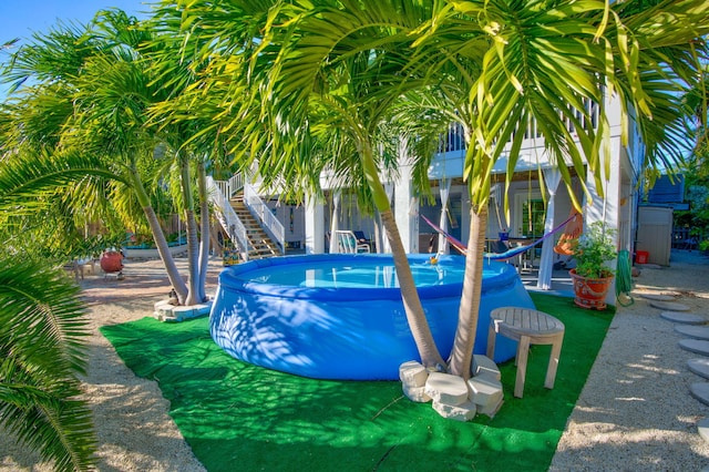 outdoor pool featuring stairway