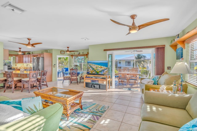 living room featuring ceiling fan, visible vents, and light tile patterned floors