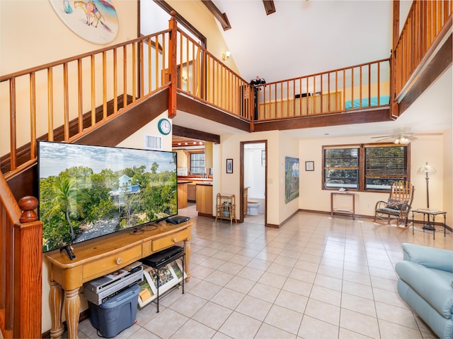 living room with visible vents, baseboards, light tile patterned floors, high vaulted ceiling, and a ceiling fan