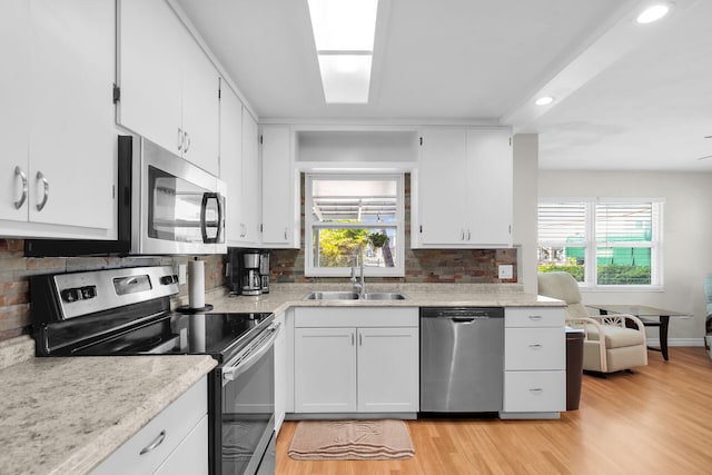 31034 Hollerich Dr, Big Pine, FL 33043 - kitchen featuring stainless steel appliances, light wood finished floors, recessed lighting, backsplash, and white cabinets