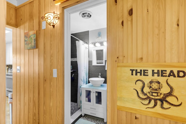 31034 Hollerich Dr, Big Pine, FL 33043 - bathroom featuring vanity, wooden walls, and curtained shower