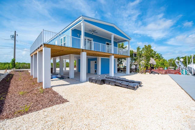 rear view of property featuring a ceiling fan and a patio area