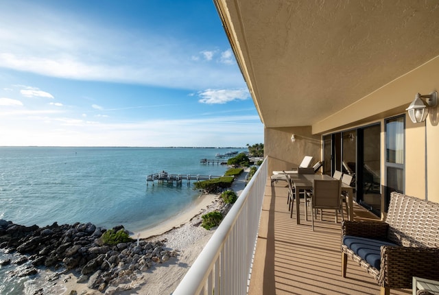 balcony with a water view and a view of the beach