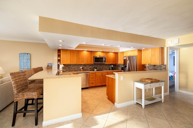 kitchen with open shelves, tasteful backsplash, appliances with stainless steel finishes, a peninsula, and a kitchen bar