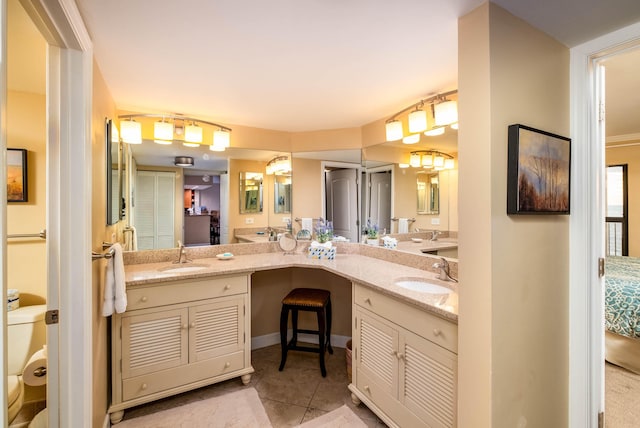 bathroom with tile patterned flooring, a sink, toilet, and double vanity