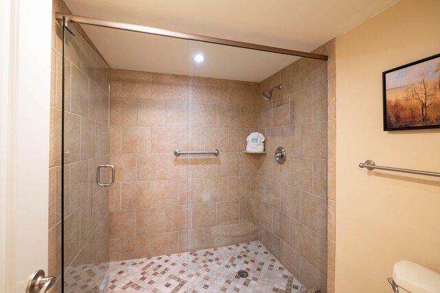 full bath featuring a shower stall and toilet